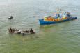 Aerial view of four fishing vessels on the water -- one much larger than the others.